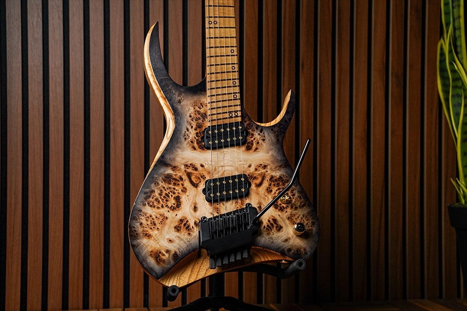 Kiesel Guitars Kyber Headless 6 string tremolo with poplar burl top, translucent black burst finish, black hardware, gold pole pieces, and 1-piece roasted swamp ash body