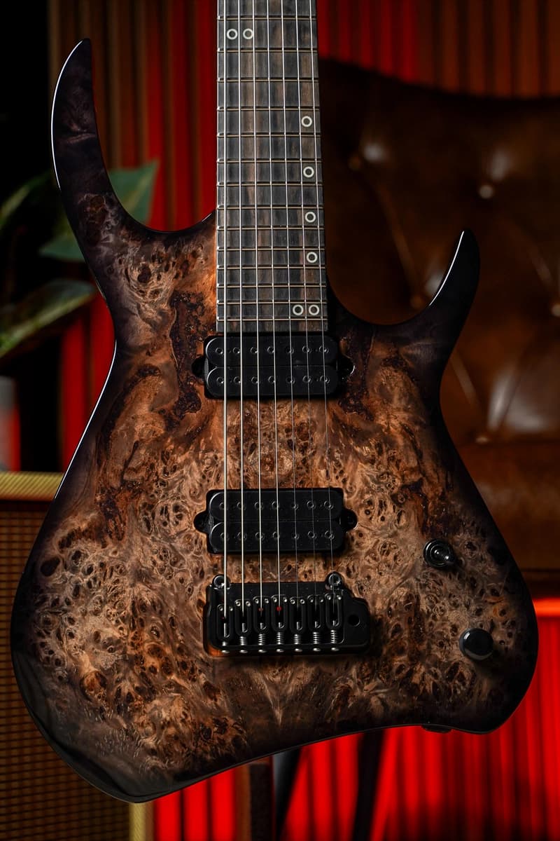 Kiesel Guitars Kyber 7 string tremolo with poplar burl top, thin black burst edges, ebony fingerboard, black hardware, black pole pieces, and staggered offset ring inlays