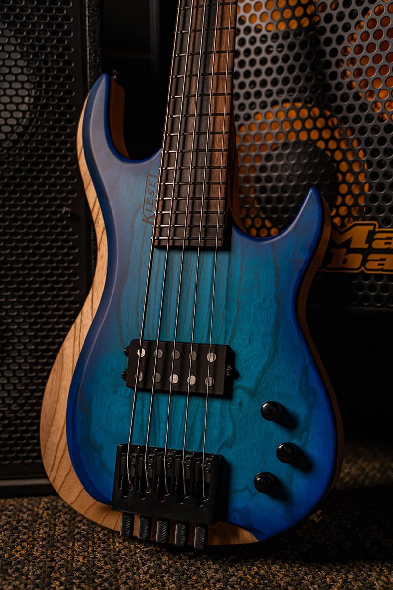 Kiesel Guitars Osiris Bass 5 String Bass with swamp ash body and swamp ash top, translucent blue finish, raw tone top coat, rear of body natural clear RNC, black logo, royal ebony fingerboard, no top inlays NIN, HB2 pickup in sweet spot, black hardware