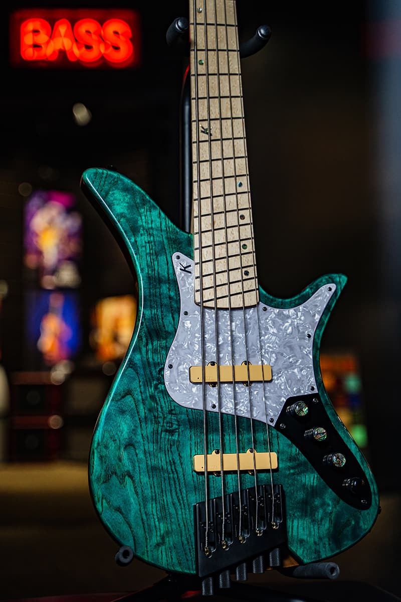 Kiesel Guitars Thanos Bass 5 String Multiscale Bass With translucent teal finish, gloss top coat, white pearloid pickguard, cream pickup covers, 12th fret K logo with staggered offset dot inlays, swamp ash body, black hardware