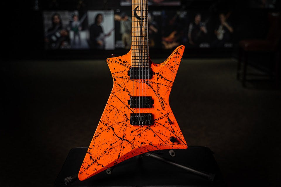 Kiesel Guitars Hyperdrive H6H with palemoon ebony fingerboard, lambo orange finish, black splatter, black acrylic crescent moon with staggered offset dot inlays, black hardware