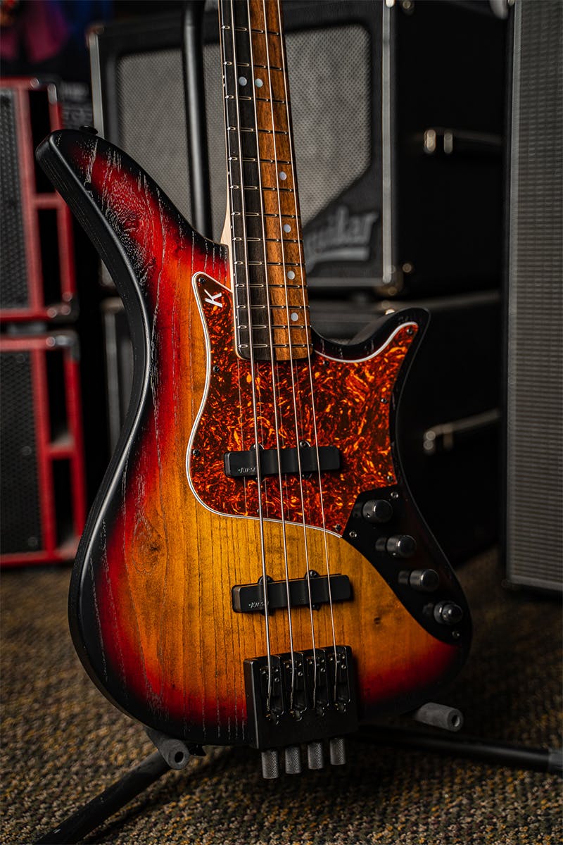 Kiesel Guitars Thanos Bass With traditional sunburst finish, raw tone top coat, swamp ash body, red tortoise shell pickguard, black hardware, royal ebony fingerboard, mother of pearl staggered offset dot inlays