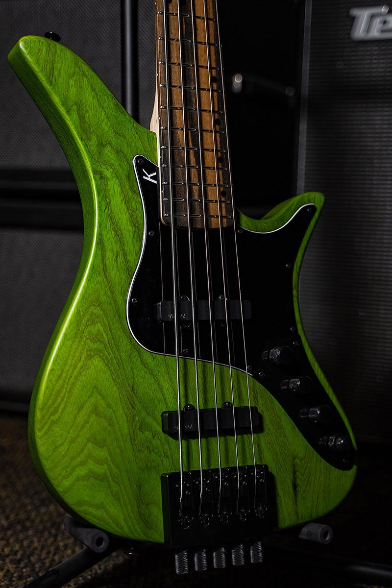 Kiesel Guitars Thanos 5 String Bass With moss green finish, clear satin matte top coat, black hardware, black pickguard, royal ebony fingerboard, swamp ash body, black acrylic staggered offset dot inlays