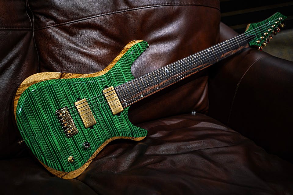 Kiesel Guitars Vanquish 7 string KV7H with flamed maple top, black limba body, translucent emerald green finish, gold hardware, gold pickup covers, royal ebony fingerboard, rear natural clear RNC
