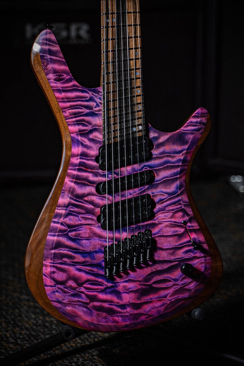 Kiesel Guitars Vanquish 7 string multiscale with master grade quilted maple top, pink candy finish, walnut body, royal ebony fingerboard, black hardware, black pole pieces, humbucker-single-humbucker HSH CAP