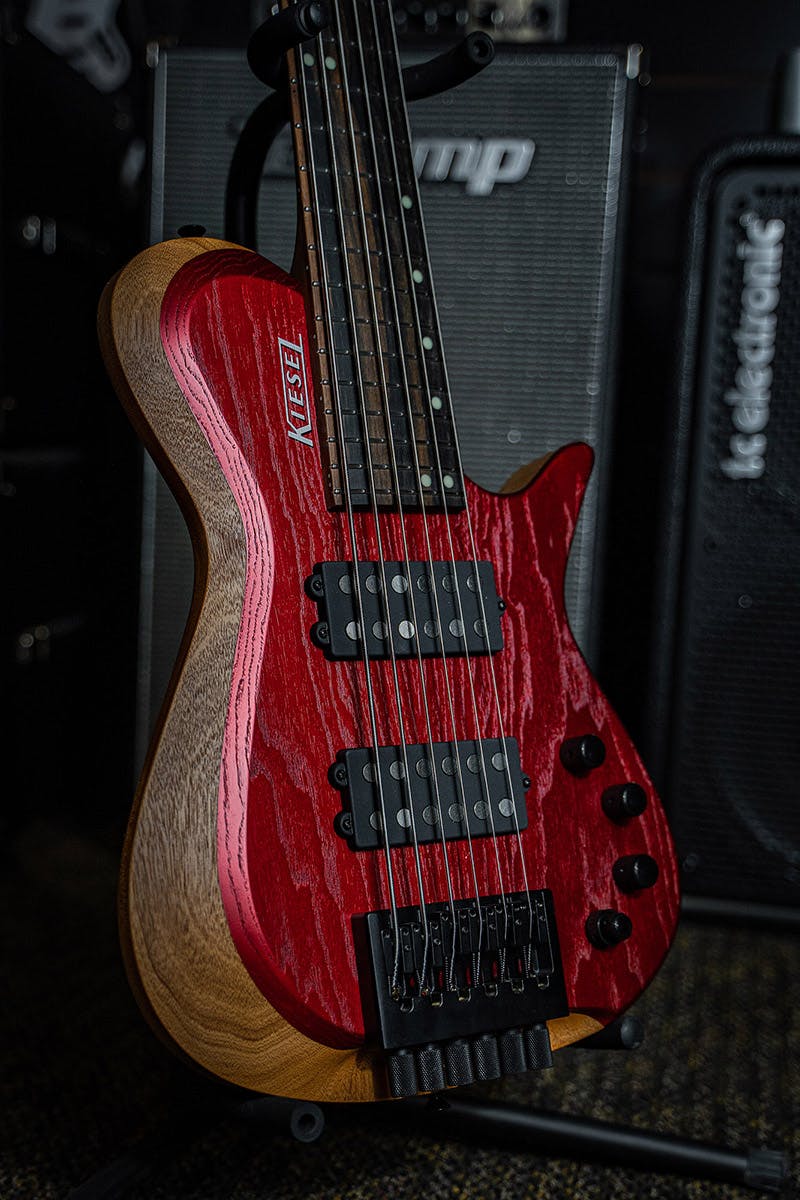 /Kiesel Guitars Zeus Bass 6 String with swamp ash top, raw tone blood red finish, HB2 pickups, rear of body natural clear RNC, walnut body, royal ebony fingerboard, luminlay staggered offset dot inlays, black hardware