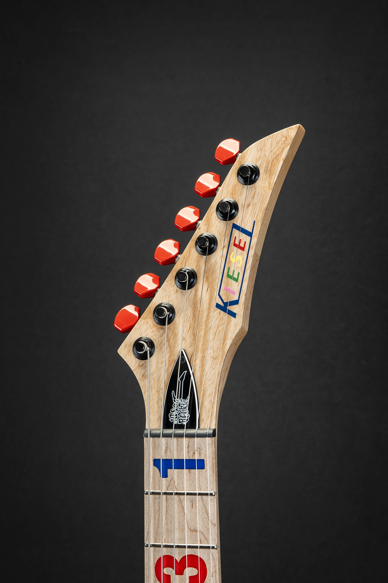 Kiesel headstock with colorful logo and premium red tuning pegs